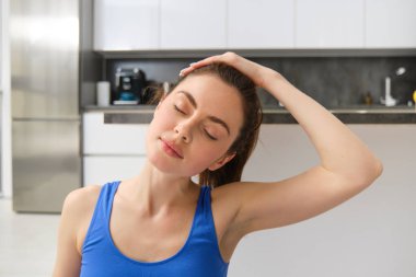 Spor salonundaki yakın çekim kadın, antrenman, evden antrenman, boyun masajı, oturma odasında egzersiz. Spor ve refah kavramı