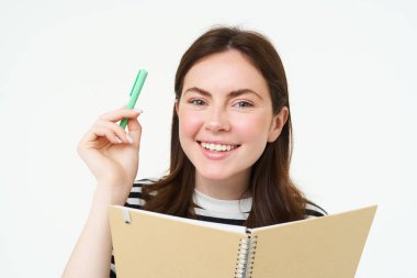 Güzel bir genç kadın resmi, elinde defter tutan öğrenci, not defteri ve kalem, gülümseyen ve mutlu görünen, beyaz arka planda soyutlanmış..