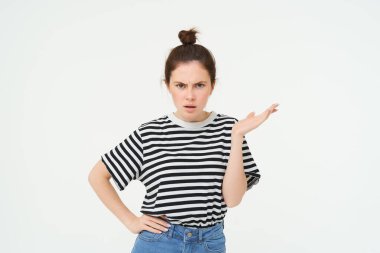 Hüsrana uğramış, şikayet eden, kafası karışmış, omuz silkmiş, kaşlarını çatmış, beyaz arka planda duran bir kadın resmi..