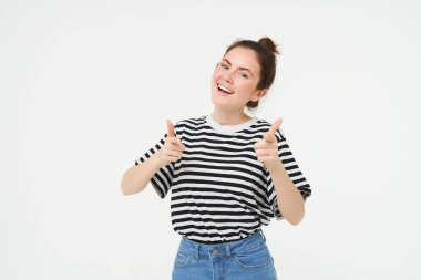 Kendine güvenen, güzel bir kadının portresi, başparmağını kaldırıyor, ürün öneriyor, beğeniyor ve onaylıyor, beyaz arka planda duruyor..