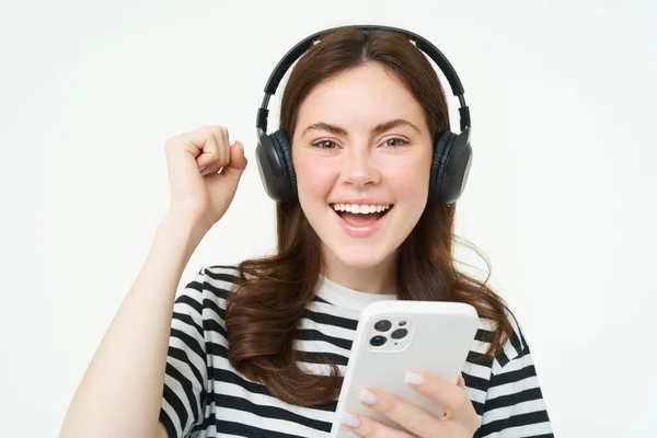 Menina Entusiasmada Fones Ouvido Segurando Smartphone Sorrindo Animando Comemorando Levantando — Fotografia de Stock