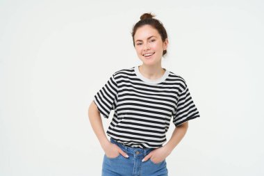 25 yaşında şık bir kadının portresi, neşeli ve motive olmuş görünüyor, beyaz arka planda poz veriyor..