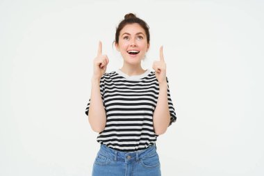 Yaşam tarzı ve reklam konsepti. Genç, gülümseyen bir kadın, modern bir kız, reklamları işaret eden, afişi gösteren, mesajlı bir yer, beyaz arka planda izole edilmiş..