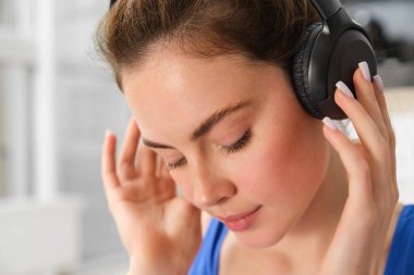 Kablosuz kulaklıkla güzel bir kadının yüzü, sesi seviyor, kablosuz kulaklıkla müzik dinliyor..