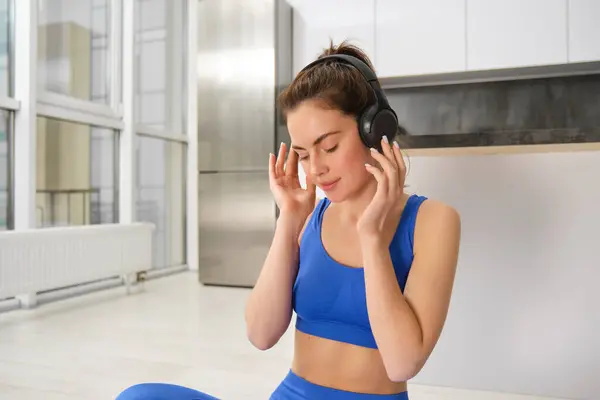 Mladá Žena Nasadí Bezdrátové Sluchátka Poslouchat Hudbu Při Cvičení Doma — Stock fotografie
