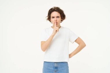 Esmer, genç bir kadının susması, sessiz olması, parmaklarını dudaklarına bastırması, beyaz stüdyo arkaplanının üzerinde duran sır saklaması..