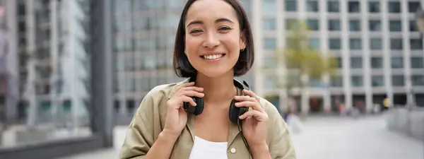 Portrét Usměvavé Asijské Dívky Sluchátky Pózování Centru Města Poslech Hudby — Stock fotografie