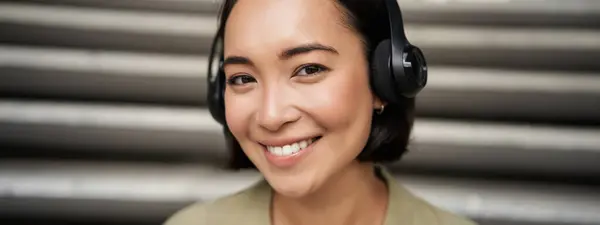 Close Portrait Smiling Asian Girl Headphones Listens Music Outdoors Looking — Stock Photo, Image