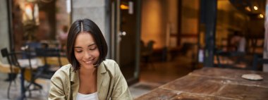 Öğrenci çalışıyor, kafede dizüstü bilgisayarla oturuyor uzaktan çalışıyor, dizüstü bilgisayar kullanıyor. Teknoloji ve insanlar