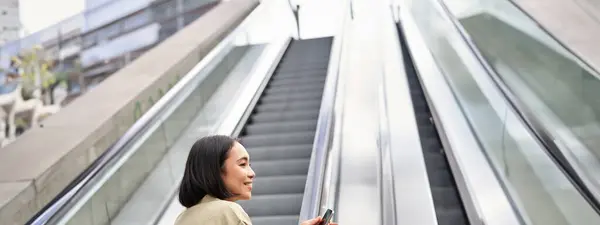 Ung Lycklig Kvinna Står Rulltrappan Med Smartphone Går Upp Promenader — Stockfoto