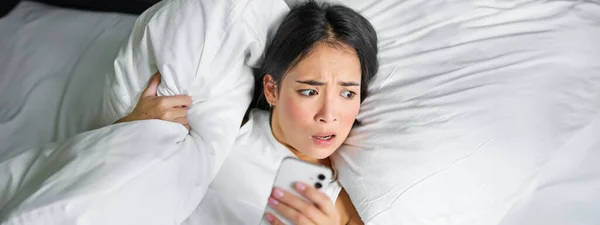 Close Portrait Asian Girl Lying Bed Looking Smartphone Concerned Waking — Stock Photo, Image