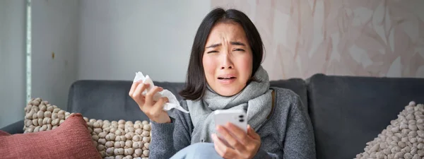 Asiática Chica Con Gripe Sienta Casa Llora Molesto Sostiene Teléfono —  Fotos de Stock