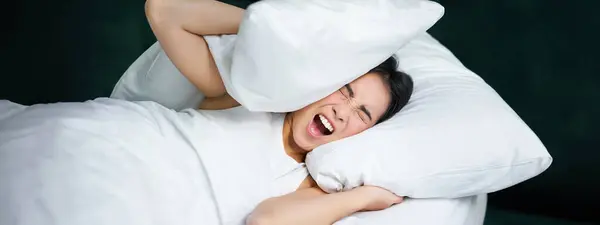 불면증에 시달리는 침대에 베개로 수면을 취하고 밤에는 시끄러운 소음으로 불안을 — 스톡 사진