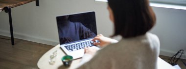 Kadının arka görünümü, dizüstü bilgisayarda yazma ve çalışma, bilgisayar ekranı kopya alanı için boş, kız öğrenci uzaktan çalışıyor.