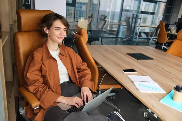 Business and lifestyle concept. Young woman in casual clothes, working on laptop, sitting in office.