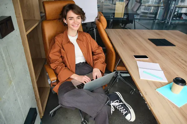 Business and lifestyle concept. Young woman in casual clothes, working on laptop, sitting in office.
