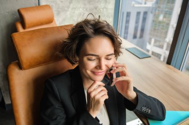 Başarılı kadın portresi, cep telefonuyla konuşan satış elemanı, sohbet eden, ofiste oturan..