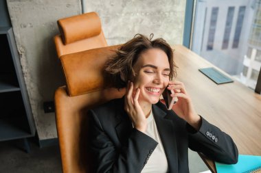 Başarılı kadın portresi, cep telefonuyla konuşan satış elemanı, sohbet eden, ofiste oturan..