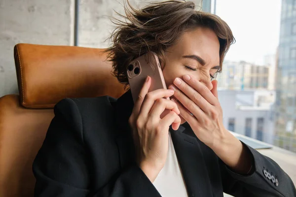 Close up portrait of woman laughing on phone call, corporate lady, manager working and having a telephone conversation, yawning from boredom.