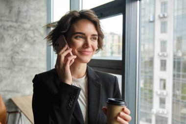 İş kadınının cep telefonuyla konuşurken, gülümserken, ofisiyle kahve içerken yakın plan çekimleri..