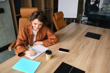 Not yazan bir kadının portresi. Ofiste belgelerle çalışan..