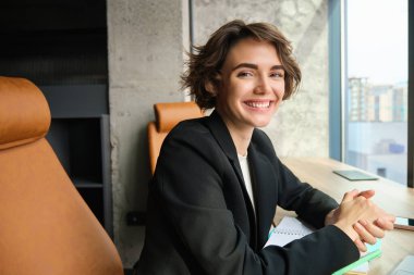 Akıllı telefonlu çalışkan bir kadının portresi, ofisinde oturan, iş kadını....