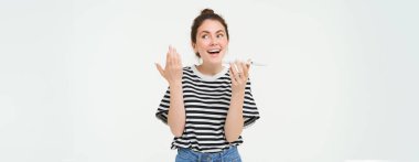 Konuşkan, mutlu, genç bir kadının cep telefonuyla konuşması, sesli mesaj kaydetmesi, telefonda bir şeyler açıklaması, beyaz arka plan..