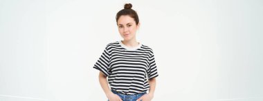 Çizgili t-shirt ve kot giyen, kendinden emin ve mutlu görünen, kameraya gülümseyen, samimi duygular, beyaz arka plan.