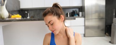 Evde kadın egzersizi, başını ve boynunu esnetme, yoga öncesi ısınma egzersizleri, oturma odasında spor..