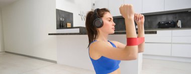 Evde odaklanmış sporcu kadın egzersizi, kollar için elastik direnç bandı, oturma odasında esneme egzersizleri, aerobik eğitimi..