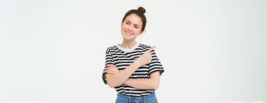 Yaşam tarzı ve reklam konsepti. Genç, gülümseyen bir kadın, modern bir kız, reklamları işaret eden, afişi gösteren, mesajlı bir yer, beyaz arka planda izole edilmiş..