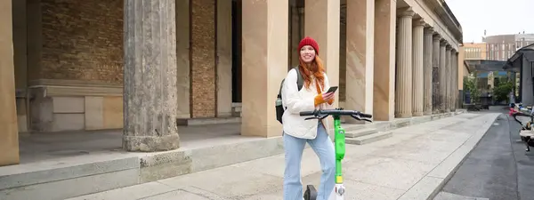 Redhead Girl Tourist Backpack Uses Mobile Phone Rent Scooter Streets — Stock Photo, Image