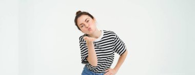 Güzel esmer kadının portresi kameraya hava öpücüğü gönderir, avuç içi dudaklarını tutar, beyaz arka planda izole olur..