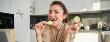 Mutfakta gülümseyen genç bir kadının portresi. Yemek pişiriyor, kabak doğruyor, sebze tutuyor ve evde vejetaryen yemeği hazırlıyor..