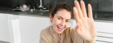 Çekici, genç, neşeli kız mutfakta yemek pişiriyor, para kazanıyor, yemek tarifi kitabını tutuyor, fikirleri var..