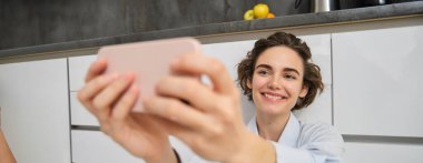 Mutlu, güzel bir kadının portresi akıllı telefondan selfie çeker, elini cep telefonuyla uzatır ve kendi fotoğrafını çeker, cep telefonuyla video kaydını kaydeder..