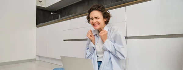 stock image Candid, smiling young woman sits on floor at home, works remotely, connects to online group chat meeting, using laptop to talk with friend.