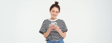 Gülümseyen genç bir kadın resmi, cep telefonu, akıllı telefon uygulaması, beyaz arka plan üzerinde izole edilmiş.