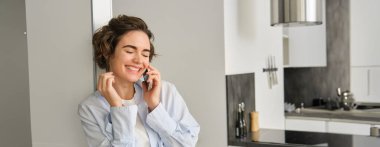 Mutlu bir kadının cep telefonuyla konuşması, sohbet etmesi, akıllı telefon kullanması, gülmesi ve gülümsemesi, evden araması..
