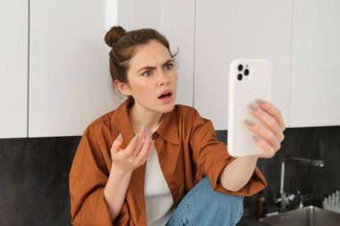 Kafası karışmış bir kadının portresi, akıllı telefonlarda konuşmak, video sohbetleri, hayal kırıklığını ve hayal kırıklığını ifade ediyor..