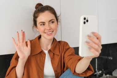 Genç bir kadının video görüntüsü, internet üzerinden konuşmak için akıllı telefon uygulaması, sosyal medya blogu için kendini kaydetmesi, mutlu görünüyor..