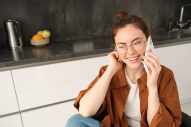 Genç bir profesyonelin portresi, ev sahibi, cep telefonuyla konuşan, uzaktan kumandayla iş arkadaşını arayan. Öğrenci çalışıyor ve telefona cevap veriyor, dizüstü bilgisayarın yanında oturuyor..