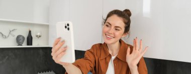 Genç bir kadının video görüntüsü, internet üzerinden konuşmak için akıllı telefon uygulaması, sosyal medya blogu için kendini kaydetmesi, mutlu görünüyor..