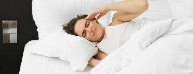 Kadın kendini iyi hissetmiyor, yatağa uzanıyor, başını okşuyor ve kaşlarını çatıyor, baş ağrısı ve şiddetli migreni var. Sağlık ve refah kavramı