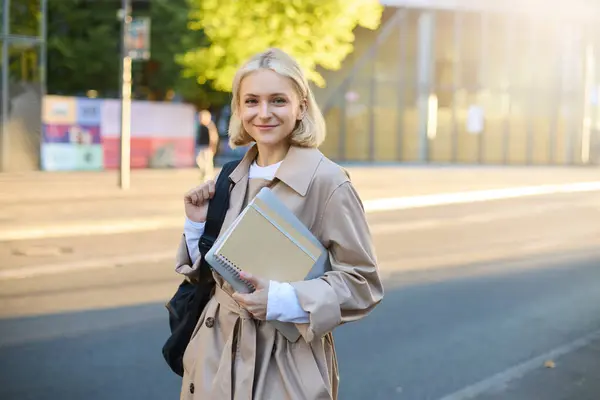 Νεαρή Ξανθιά Φοιτήτρια Στο Δρόμο Κρατώντας Ημερολόγια Και Σημειωματάρια Κουβαλάει — Φωτογραφία Αρχείου