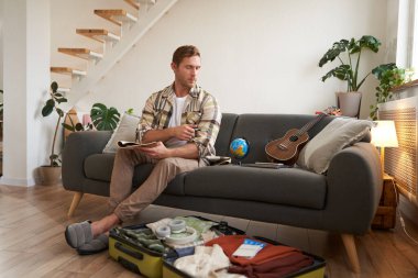 Başka bir yolculuğa hazırlanan gezginin portresi, turist valizini tatil için giysilerle doldurur, tatile çıkar..