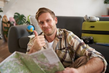 Gülümseyen adam, turist, yol haritası, baş parmağını kaldırma, tatil yeri tavsiye etme, bir gezi planlama..