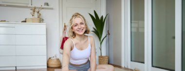 Spor ve spor yapan kadının dijital kameraya kendi videosunu kaydettiği dikey çekim, sosyal medya için egzersiz ve ev egzersizleri hakkında içerik yaratıyor..