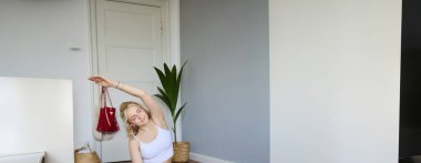 Genç atletik kadın antrenör Hatha Yoga, özel eğitmen Vasisthasana, denge pozisyonu, evde egzersiz. Sağlıklı yaşam tarzı ve refah kavramı.