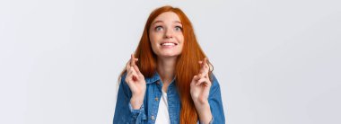 Heyecanlı ve umutlu, iyimser, tatlı kızıl saçlı kız hayallerinin gerçekleşmesini istiyor, bir şeyleri arzuluyor, başarıyı arzuluyor, iyi sonuçlar elde ediyor, gülümsüyor, gökyüzüne bakıyor ve şans diliyor..
